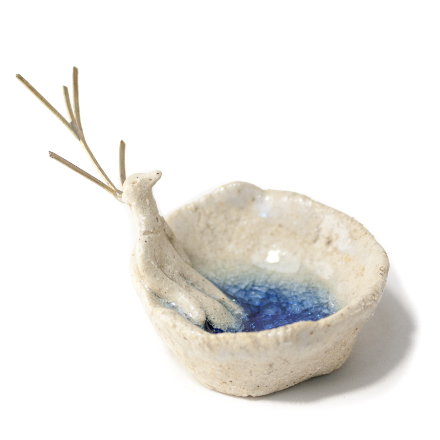 Hombre pájaro tumbado sobre cuenco de gres con fondo azul - Imagen 4