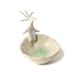 Hombre pájaro sentado sobre cuenco de gres